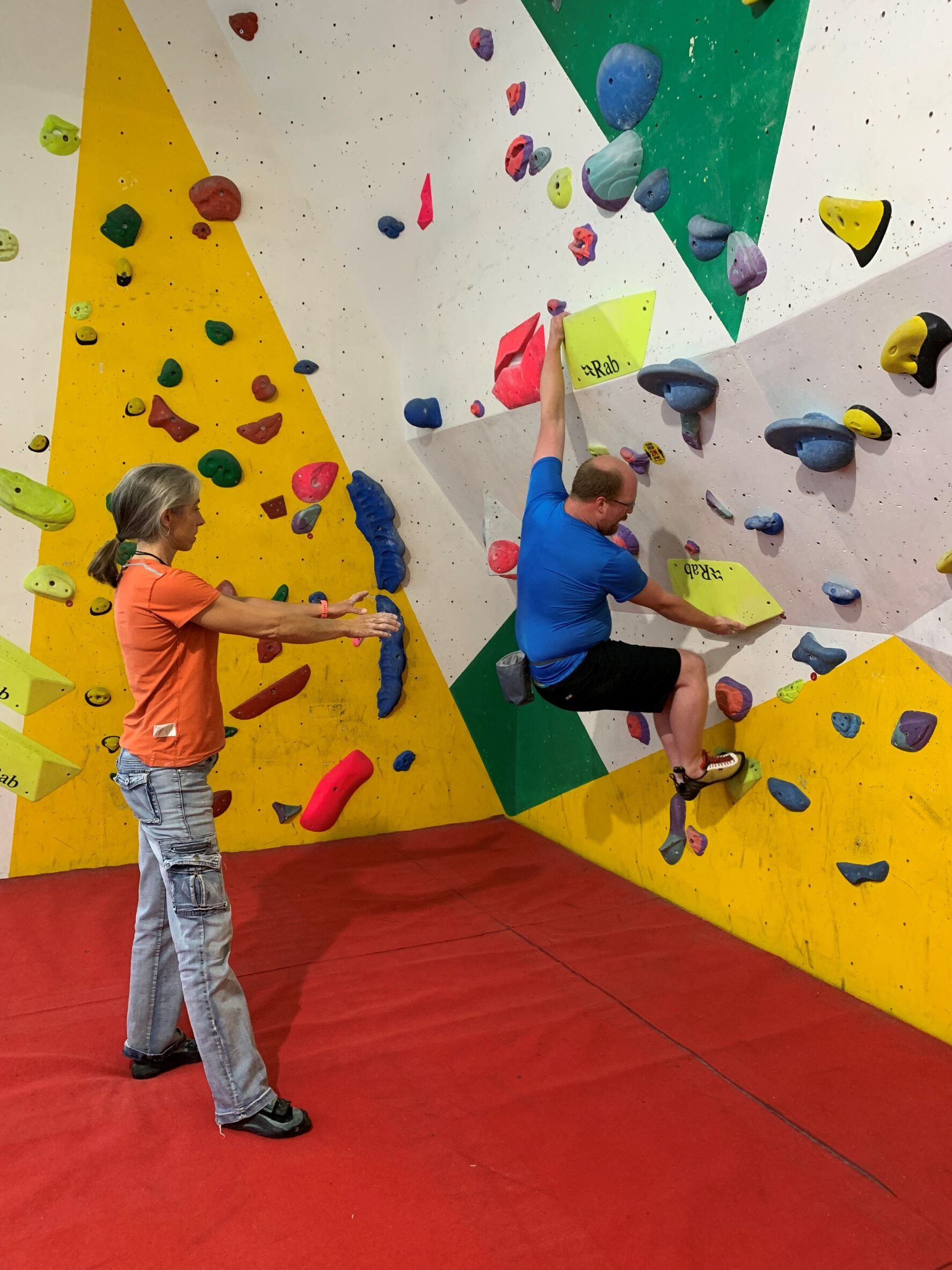 Becca Lounds coaching a student on the bouldering wall
